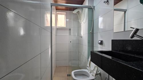a bathroom with a toilet and a glass shower at Elegância Urbana, Apartamento Exclusivo, com ar in Maringá