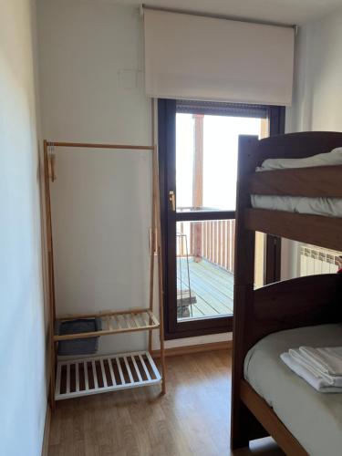 a bedroom with a bunk bed and a door to a balcony at Julia Petulia en Cerler in Cerler