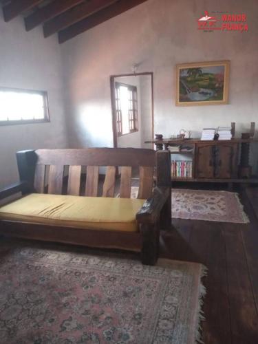um banco de madeira sentado numa sala com um tapete em GEBA1265 em Guaratinguetá