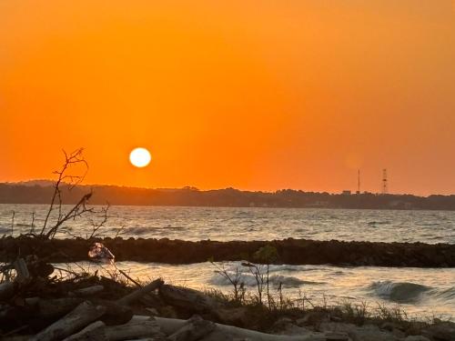 an orange sunset on the beach with the ocean at Apartamento Coveñas frente al mar in Coveñas