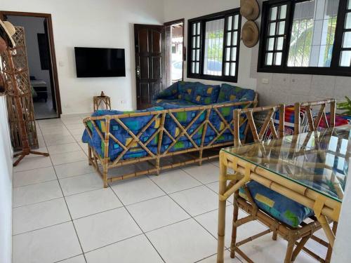 a living room with a couch and a table at Morada do Zinho - Piscina, churrasqueira, lareira e 250 metros da praia in Itanhaém