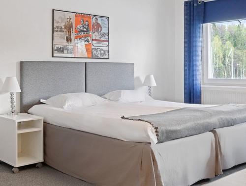 a bedroom with a large white bed with a window at Route 154, 15 min till Ullared in Älvsered