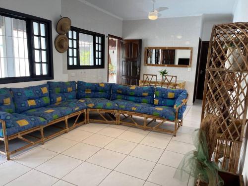 a living room with a blue couch in a room at Morada do Zinho - Piscina, churrasqueira, lareira e 250 metros da praia in Itanhaém