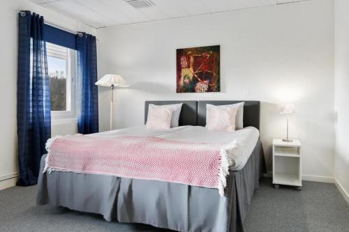a bedroom with a large bed with a pink blanket at Route 154, 15 min till Ullared in Älvsered