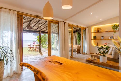 uma sala de estar com uma mesa de madeira e vista para o oceano em Casa PESQUEIRA Preá - Frente Mar! em Praia do Preá