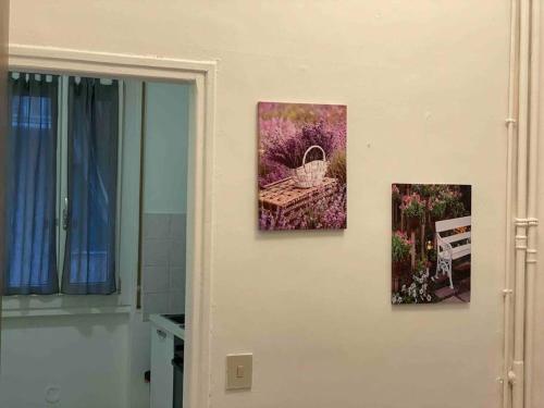 tre foto appese a un muro in un bagno di appartamento signorile a Biella