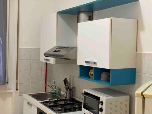 una piccola cucina con piano cottura e forno a microonde di appartamento signorile a Biella