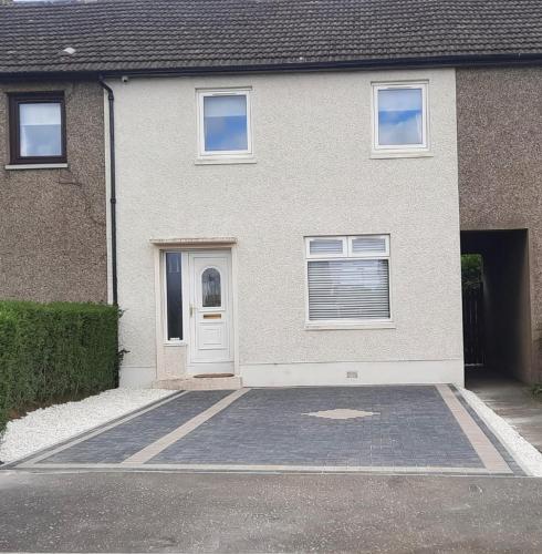a house with a white door and a driveway at Springbank Holiday Home in Dunfermline