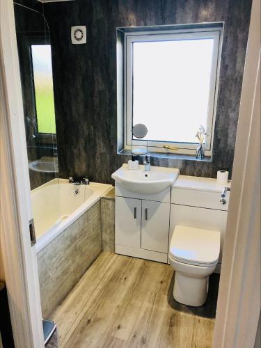 W łazience znajduje się umywalka, toaleta i wanna. w obiekcie Springbank Holiday Home w mieście Dunfermline
