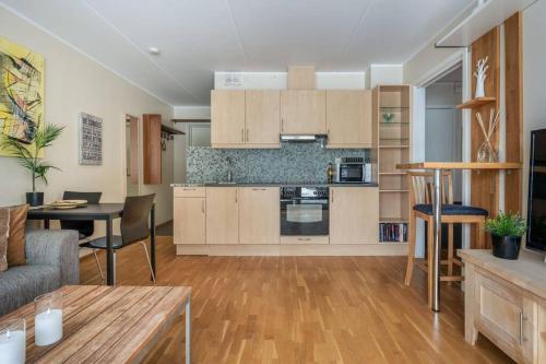 een keuken en een woonkamer met een bank en een tafel bij Cozy Cove at Solsiden - 2BR familyfriendly in Trondheim