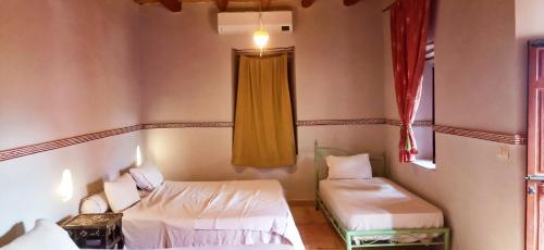 a room with two beds and a window at Dar Boumida in Lalla Takerkoust