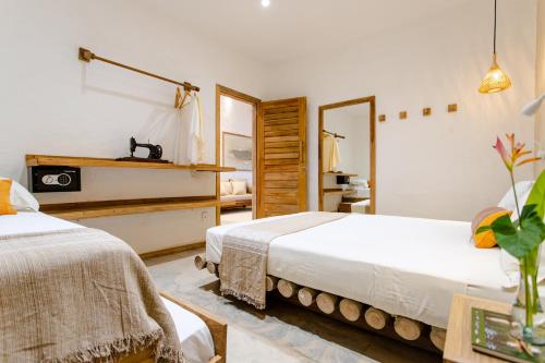 a bedroom with two beds and a mirror at Casa PESQUEIRA Preá - Frente Mar! in Prea