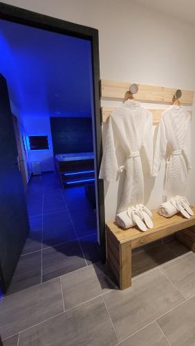 a room with two hangers with white shirts and shoes at Spa limmersion in Saint-Vincent-de-Paul