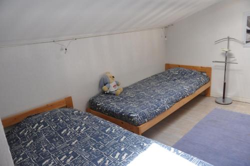 een slaapkamer met 2 bedden en een teddybeer op het bed bij Maisons du lac in Le Barcarès