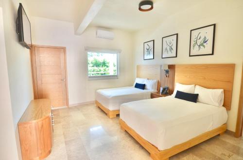 sypialnia z 2 łóżkami i oknem w obiekcie Hotel Plaza Rioverde w mieście Rioverde