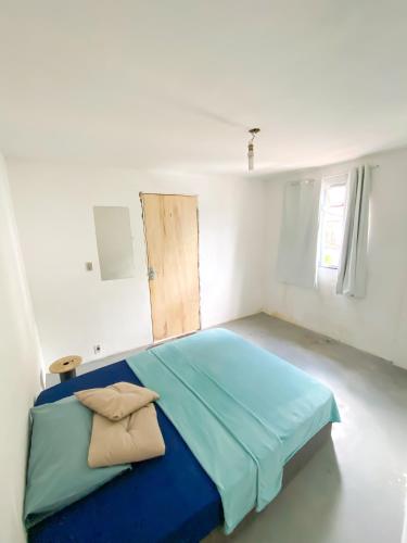 - une chambre blanche avec un lit bleu dans l'établissement Quarto Privativo no Vidigal, à Rio de Janeiro
