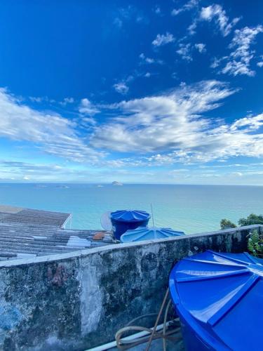 d'une vue sur l'océan depuis une corniche avec des parasols bleus dans l'établissement Quarto Privativo no Vidigal, à Rio de Janeiro