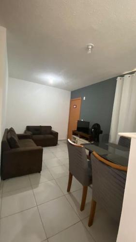 a living room with a couch and a table and chairs at Apartamento Cuiabá in Cuiabá