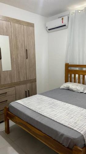 a bedroom with a bed and a wooden cabinet at Apartamento Cuiabá in Cuiabá