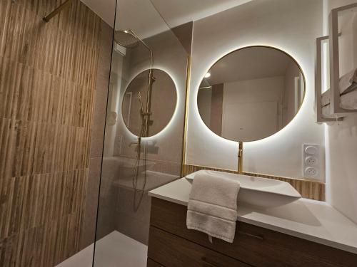 une salle de bain avec une douche, un lavabo et un miroir dans l'établissement LE JACQUARD Appartement Type 2 proche des Halles, à Narbonne