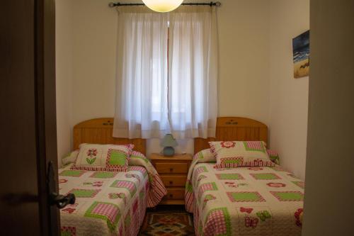 1 dormitorio con 2 camas y ventana en Apartamento La Luna Mora - A un paso del Caminito del Rey, en Carratraca