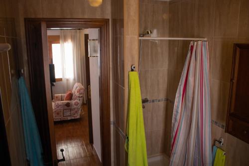 a bathroom with a shower with a yellow shower curtain at Apartamento La Luna Mora - A un paso del Caminito del Rey in Carratraca