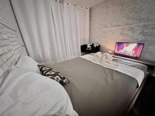 a bedroom with a bed with white sheets and a window at Appartement à Paris in Ivry-sur-Seine