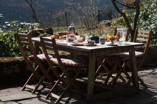 una mesa de madera con sillas y comida. en Kleines Waldglück, en Lenzkirch