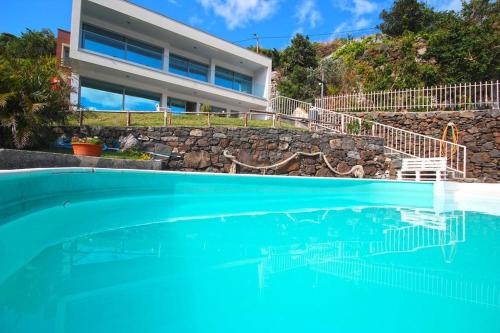 a swimming pool in front of a house at Villa Calçada in Santa Cruz