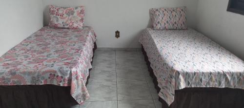 two beds sitting next to each other in a room at Casa Temporada em Aparecida com vista para Basílica in Aparecida