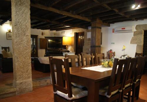 a dining room and living room with a table and chairs at Casa d'Acha in São Miguel de Acha