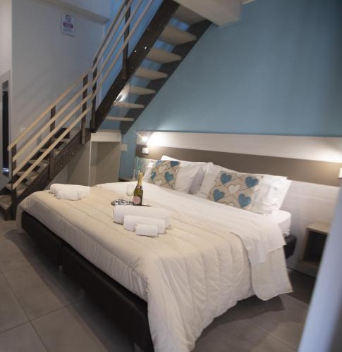 a bedroom with a large white bed with a staircase at La Perla Amantea - Rooms & Apartaments in Amantea