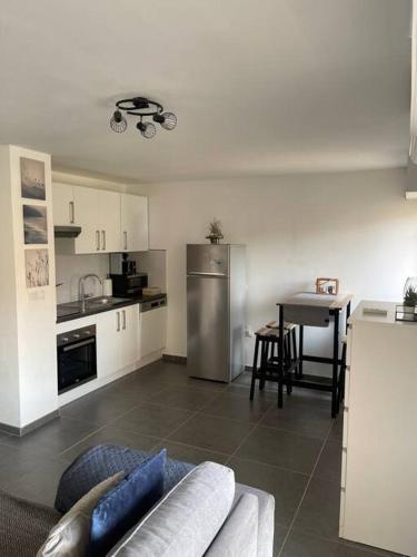 un salon avec un canapé et une cuisine dans l'établissement Proche mer et centre Appart 2 pièces Wifi&Clim, à Sainte-Maxime