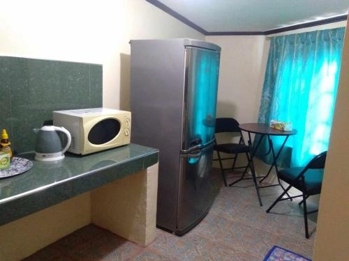 a kitchen with a refrigerator and a microwave on a counter at Casa Esmeralda in Lupao