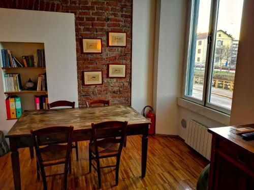 a dining room table with chairs and a brick wall at In Da House in Milan