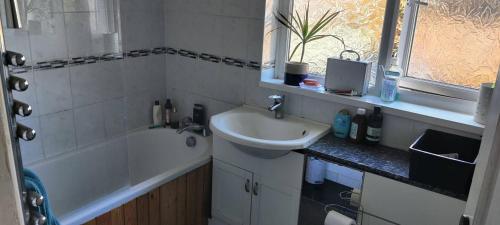 een badkamer met een wastafel, een bad en een wastafel bij Spacious Rooms close to Aylesbury Centre - Free Fast WiFi in Buckinghamshire