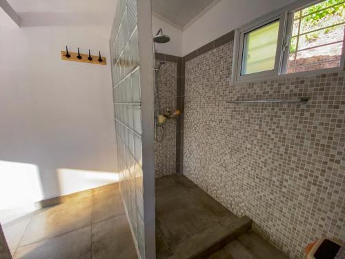 La salle de bains est pourvue d'une douche et d'une paroi en verre. dans l'établissement Passage du Soleil, à Praslin