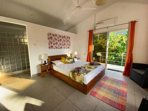 1 dormitorio con cama y ventana grande en Passage du Soleil en Praslin