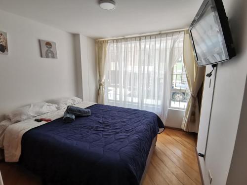 a bedroom with a bed and a tv and a window at aparta-estudio norte de Tunja cristales in Tunja
