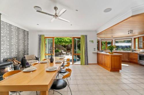 Wanaka Lake House في واناكا: مطبخ وغرفة معيشة مع طاولة وكراسي