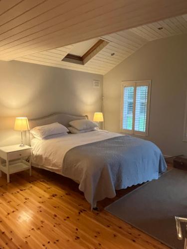 a bedroom with a bed with two lamps on it at Ballymoney, Wexford - 3 bed beach house with private beach access in Ballymoney Cross Roads