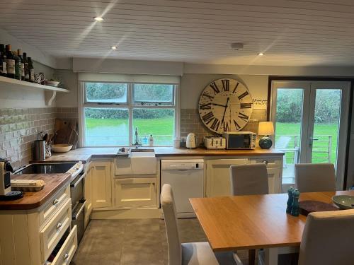 a kitchen with a large clock on the wall at Ballymoney, Wexford - 3 bed beach house with private beach access in Ballymoney Cross Roads