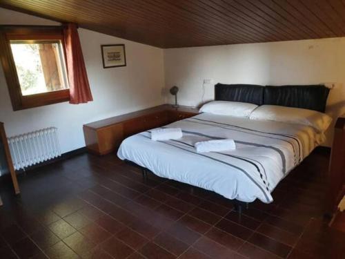 1 dormitorio con 1 cama grande y 2 toallas. en Fantástico chalet para familias y grupos, en Sant Juliá de Vilatorta