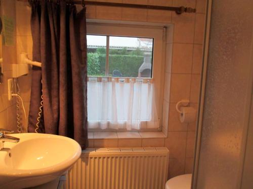 ヴァンガーラントにあるFerienwohnung Zum alten Friesen FRIESOのバスルーム(洗面台、トイレ付)、窓が備わります。