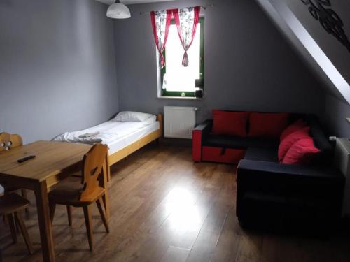- un salon avec une table, un canapé et un lit dans l'établissement Apartamenty Pokoje Zakopane, à Zakopane