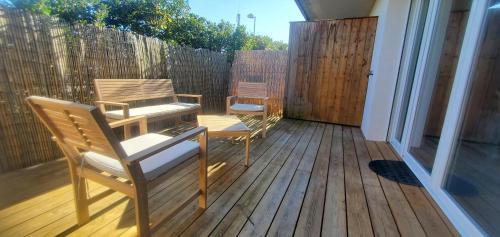 un patio avec deux chaises et une table sur une terrasse dans l'établissement T2 au cœur du bassin d'arcachon, à Gujan-Mestras