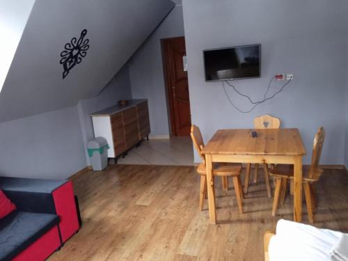 - une salle à manger avec une table et des chaises en bois dans l'établissement Apartamenty Pokoje Zakopane, à Zakopane