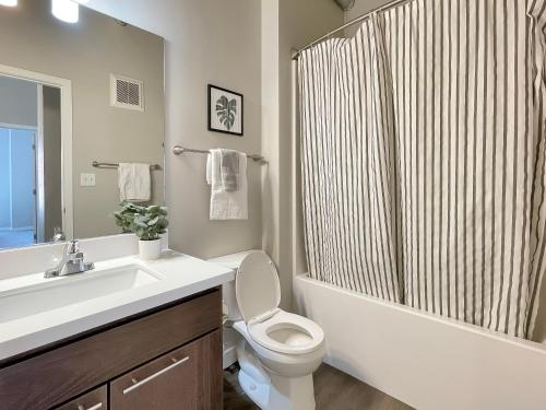 a bathroom with a sink and a toilet and a shower at 2br Skyline Apt With Panoramic Views Downtown in Des Moines