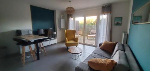 a living room with a couch and a desk at T2 au cœur du bassin d'arcachon in Gujan-Mestras