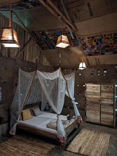 a bedroom with a bed with a mosquito net at Backyard Hostel in Moshi